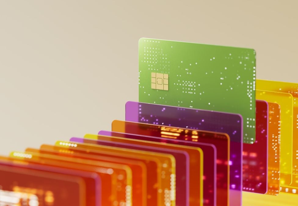 An image of a row of colorful transparent credit cards, with a lime green credit card slightly elevated above the rest.