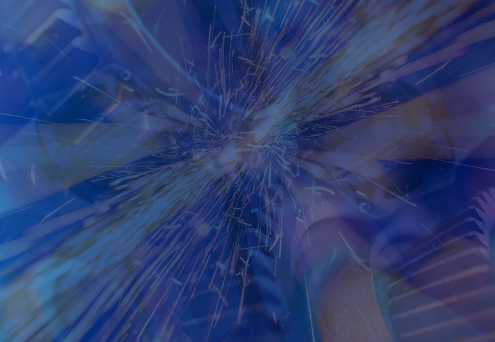 Abstract image with a deep blue overlay, showing bright sparks radiating outward from the center, layered over mechanical gears and industrial textures. The composition blends motion, light, and machinery for a dynamic, energetic effect.