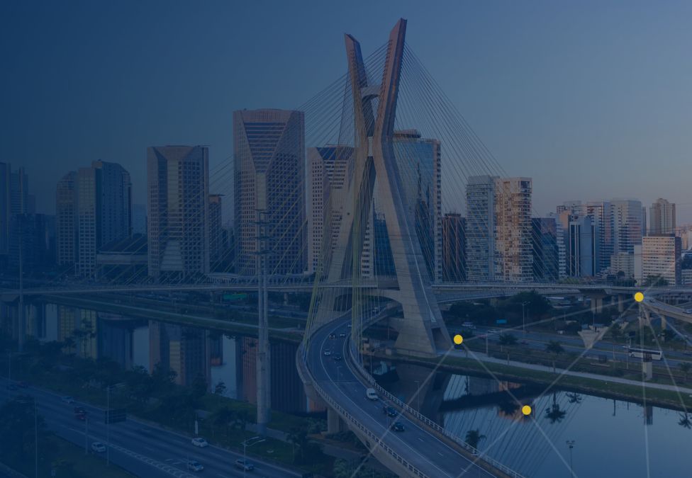 View of São Paulo’s Octavio Frias de Oliveira Bridge with modern high-rise buildings in the background, under a clear sky.