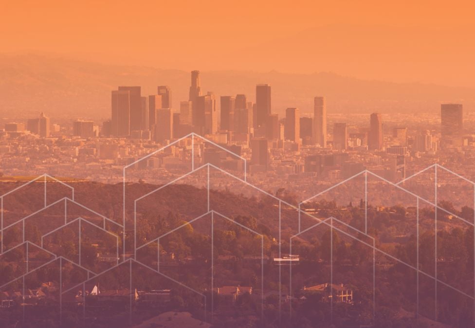 A hazy, orange-toned panoramic view of the Los Angeles skyline at sunset, overlaid with white geometric outlines of houses in the foreground.