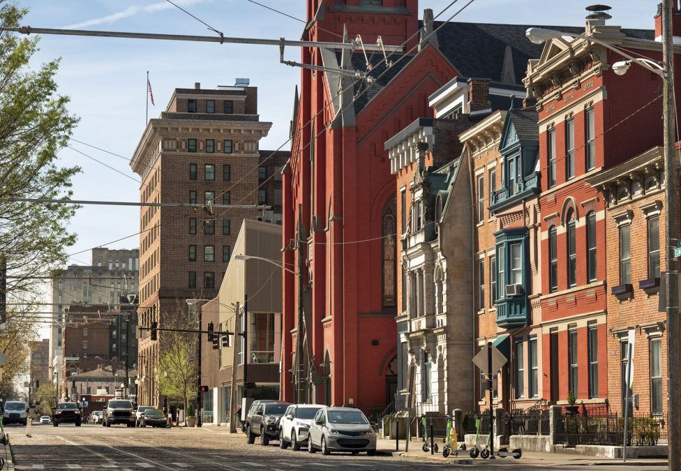 Historic urban street with colorful brick buildings and parked cars on a sunny day