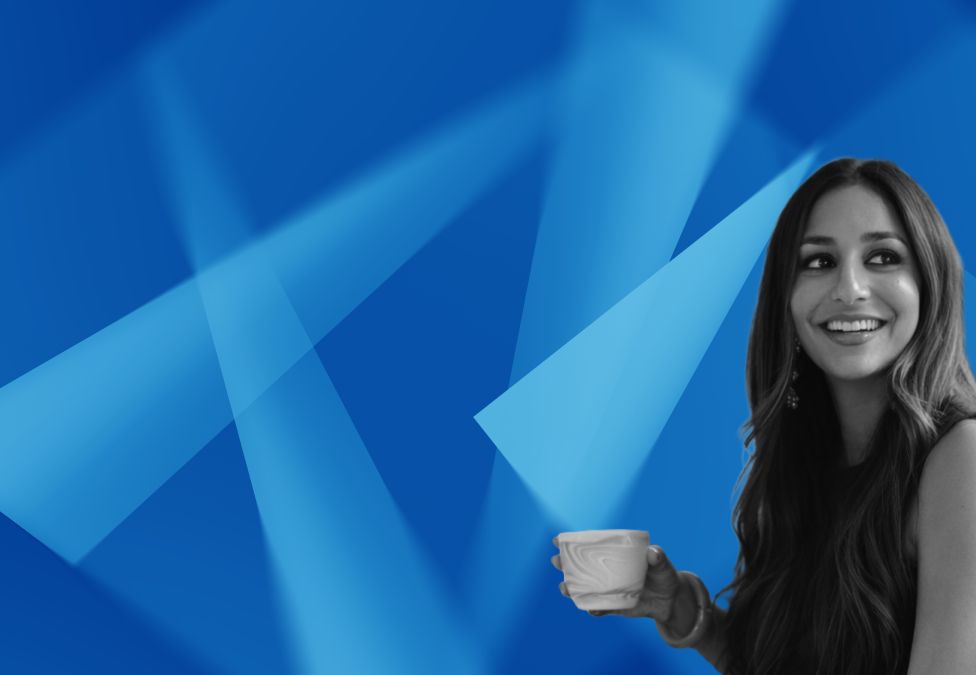 Professional woman holding coffee cup against blue geometric background