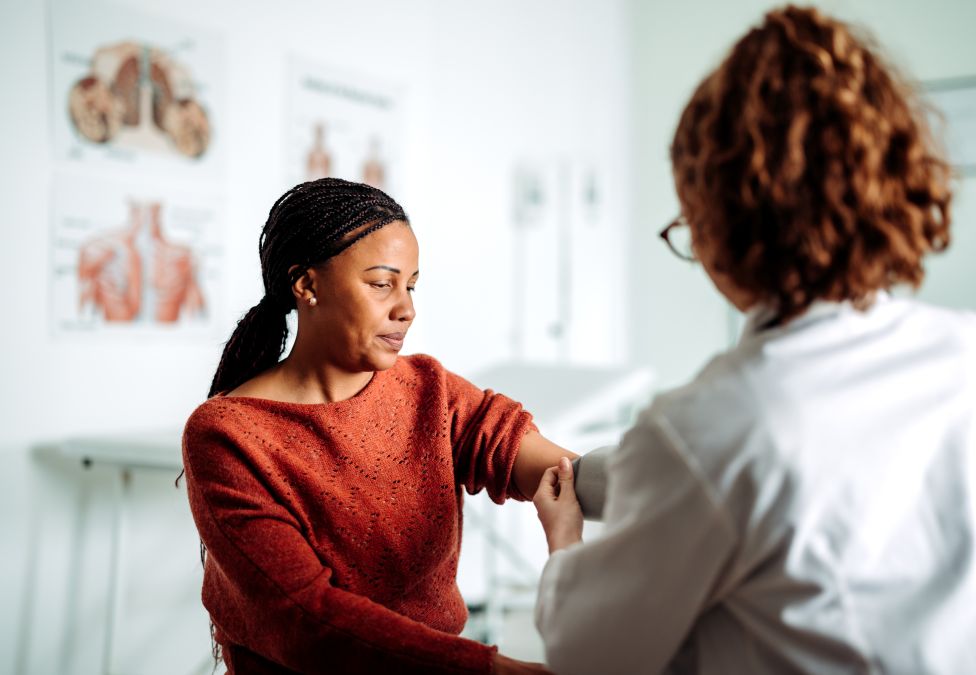 Healthcare worker tending to female patient in clinic office